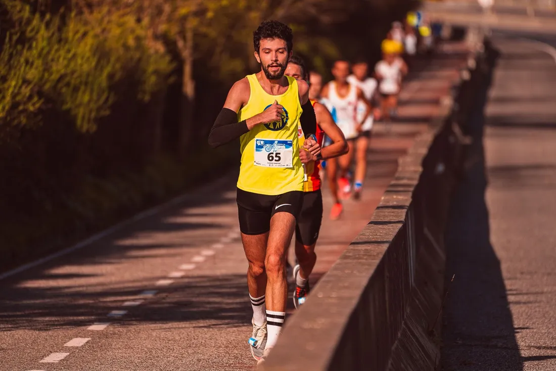 Coureur sur route au lever du jour, panneau indiquant les miles et kilomètres, style photo réaliste